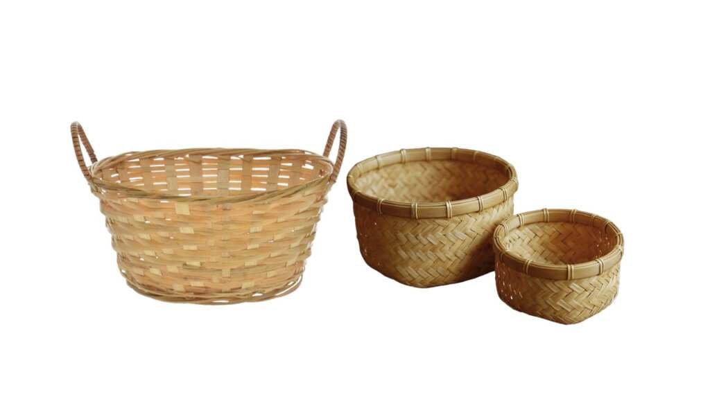 Set of three light bamboo baskets: a large oval with handles and two smaller round woven bowls.