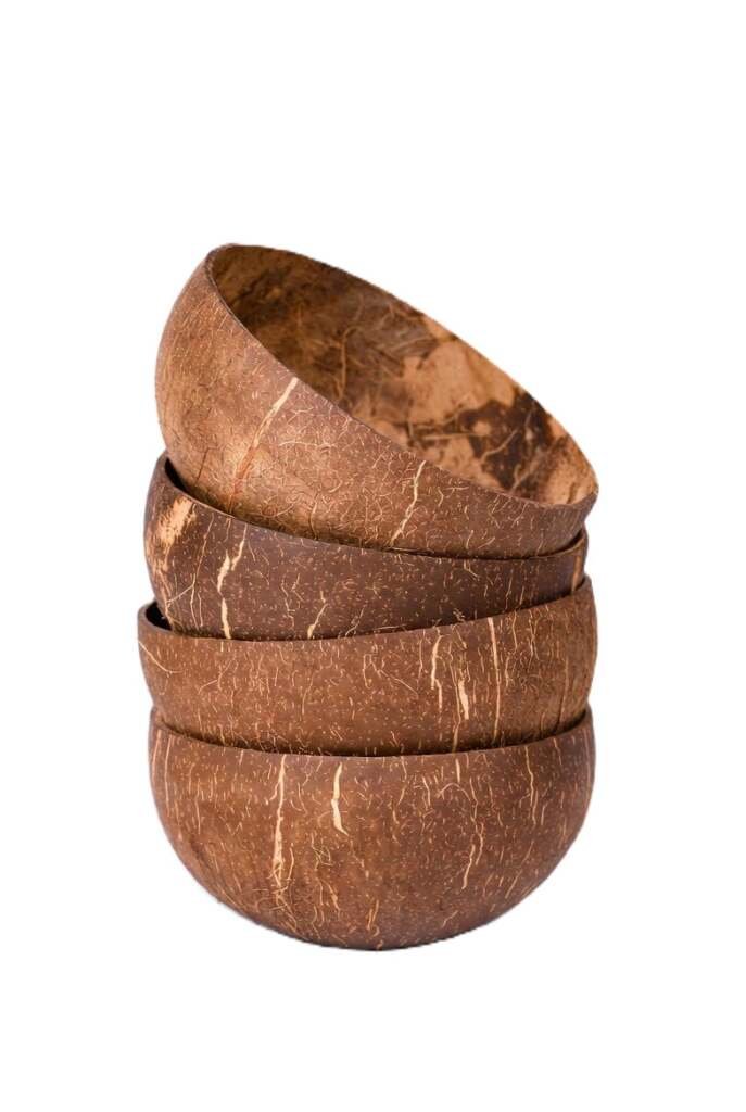 A stack of four wholesale coconut bowls showing organic grain patterns, perfect for sustainable bulk kitchen décor.