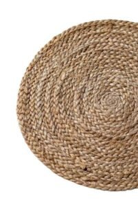 Top-down view of a circular braided natural jute fiber placemat with spiral texture.