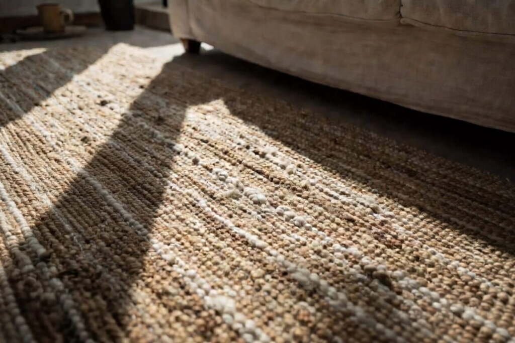 close-up detail of the chunky weave and soft natural fibers of a handmade jute and cotton blend area rug.