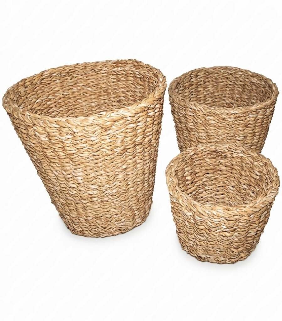 trio of tapered natural woven seagrass baskets for laundry or decorative floor storage.