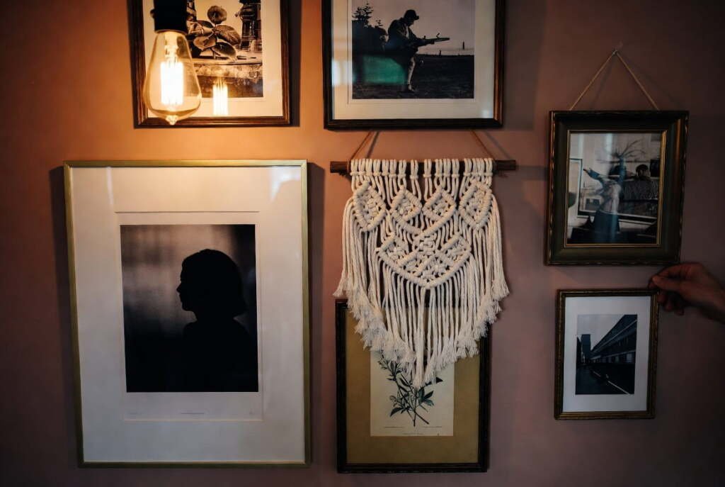 macrame-wall-hanging-gallery-wall-bohemian-home-decor Cream macrame wall hanging styled on a warm-toned gallery wall with framed photos and Edison bulb lighting